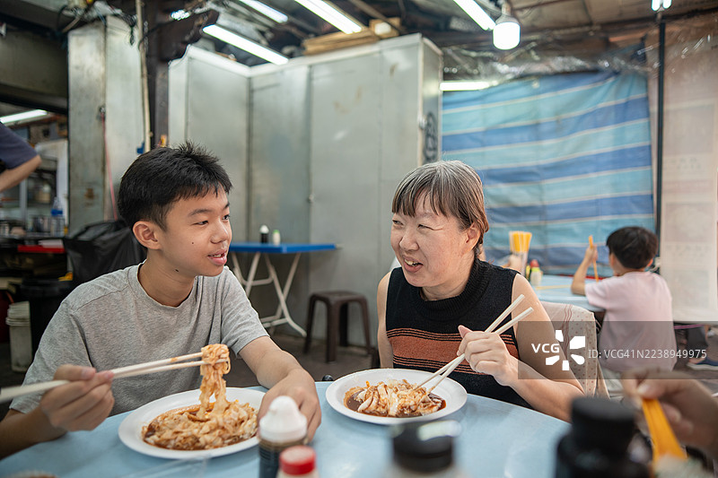 亚洲华人家庭与残疾朋友在茨厂街一同享用餐点。图片素材
