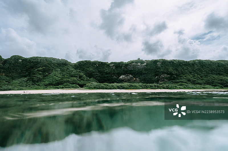 从海上看到的郁郁葱葱的绿色海岸线，日本鹿儿岛县冲永良部岛图片素材