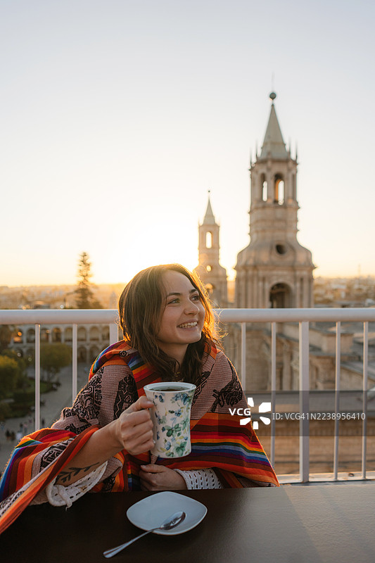 秘鲁阿雷基帕武器广场景色的阳台上，一位女士正在喝茶图片素材