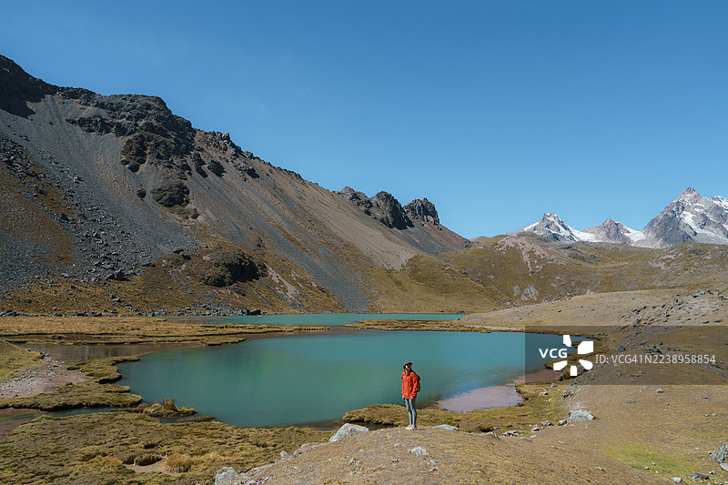秘鲁安第斯山脉湖泊附近的徒步旅行女子图片素材