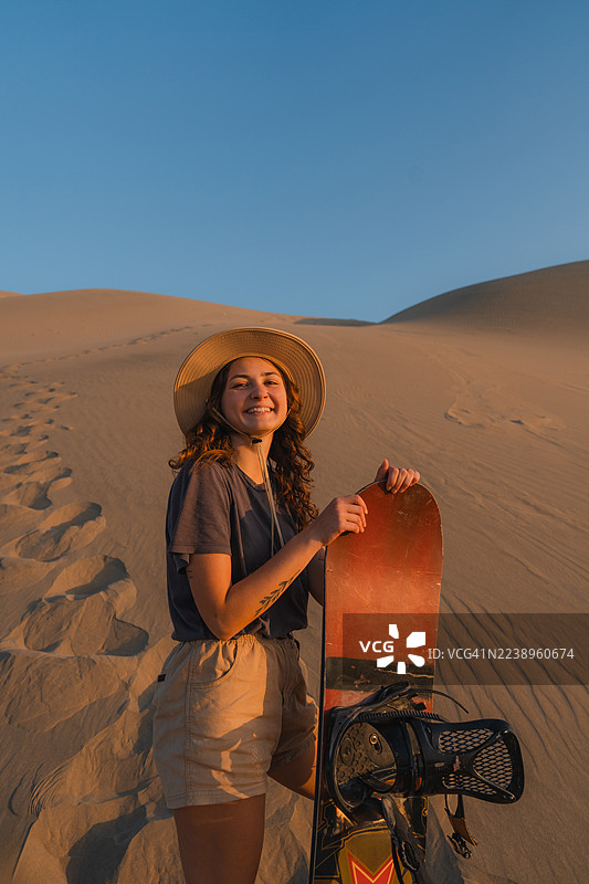 秘鲁沙漠中的女子滑沙图片素材