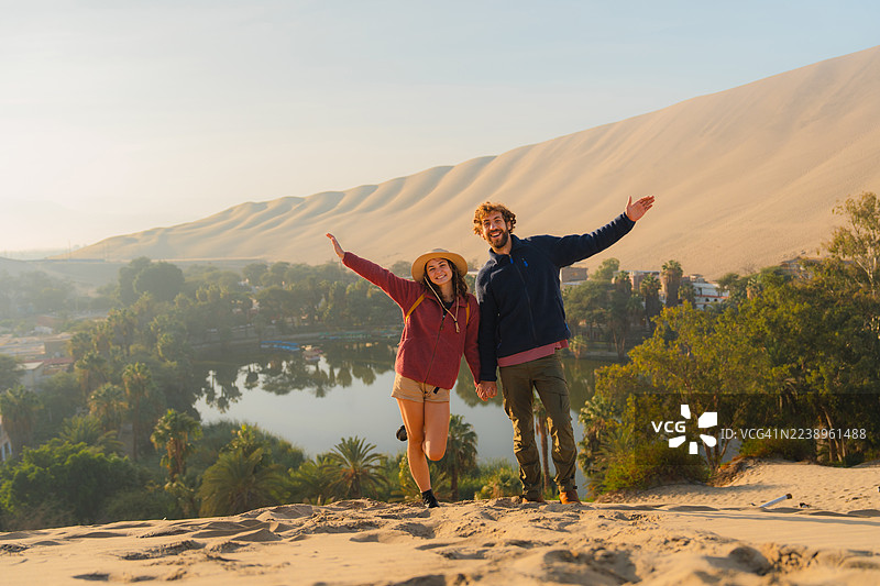 日落时分，在沙漠中的瓦卡奇纳绿洲里，一位男子和一位女子图片素材