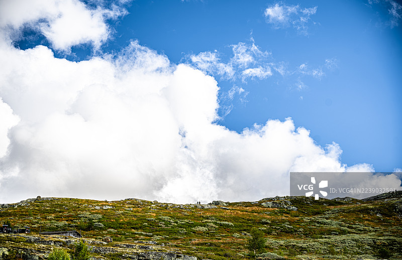 两人结伴踏上旅程，登顶后，他们正准备迈出下一步。图片素材