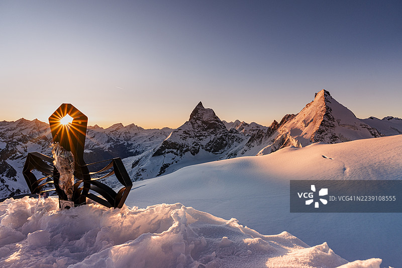 瑞士阿尔卑斯山，雪山峰顶十字架上的阳光图片素材