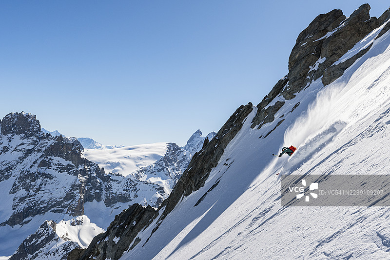 自由式滑雪者在陡峭的粉雪坡上滑降图片素材