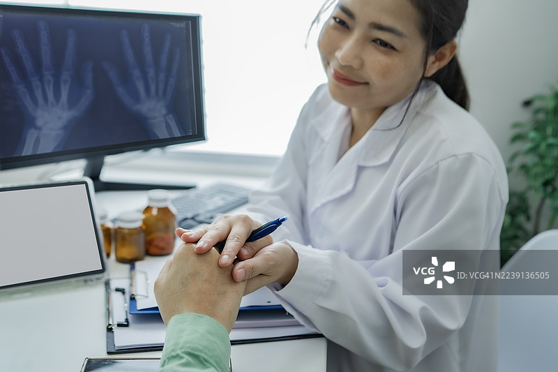 一位女性医护人员理解地倾听患者的心声，并握住患者的手，体现了医学中的同理心。图片素材