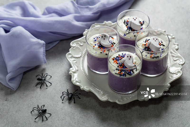 紫薯慕斯，顶部装饰有鲜奶油和棉花糖。万圣节甜点图片素材