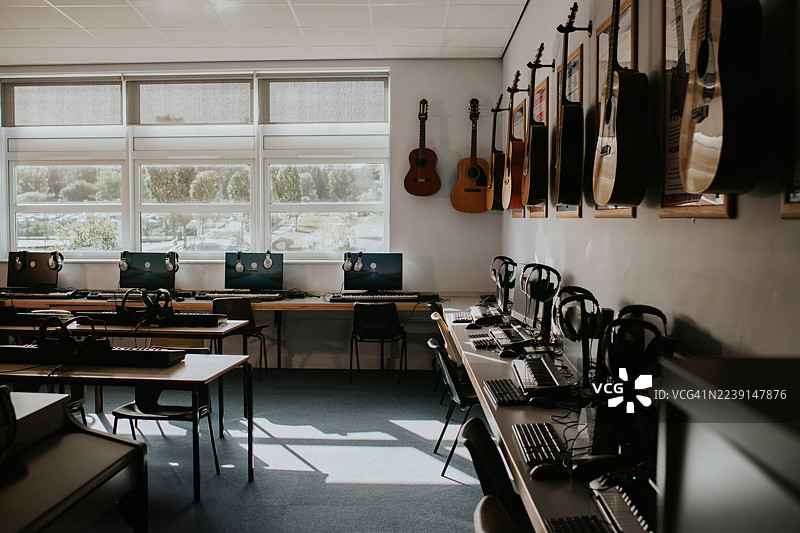 现代音乐教室，配有乐器和电脑，在午后阳光下进行创意学习。图片素材