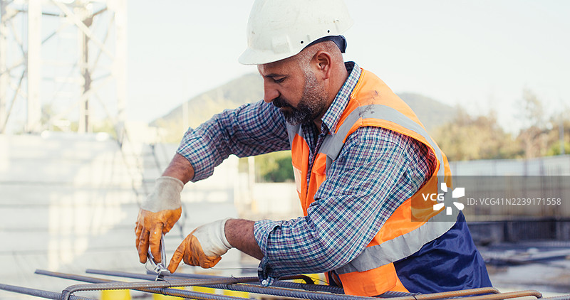 建筑工人在建筑工地为柱子绑扎钢筋笼图片素材