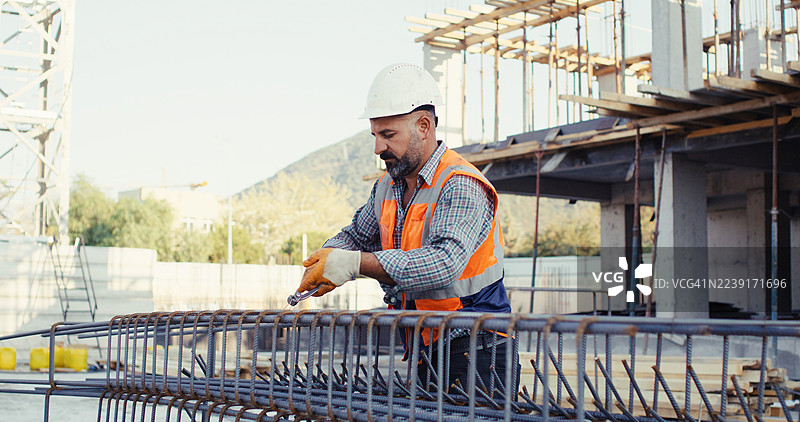 建筑工地，施工师傅正在为柱子绑扎钢筋笼图片素材