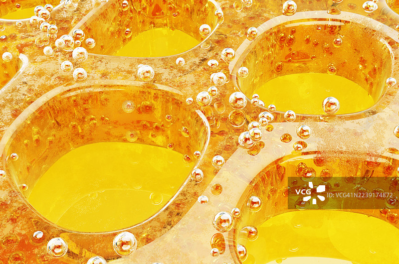 背景为黄色的蜂窝状抽象图案，由蜂蜜构成，并带有气泡。图片素材