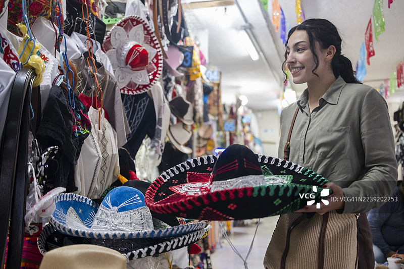 游客在九月墨西哥国庆节期间挑选要购买的查罗帽。图片素材