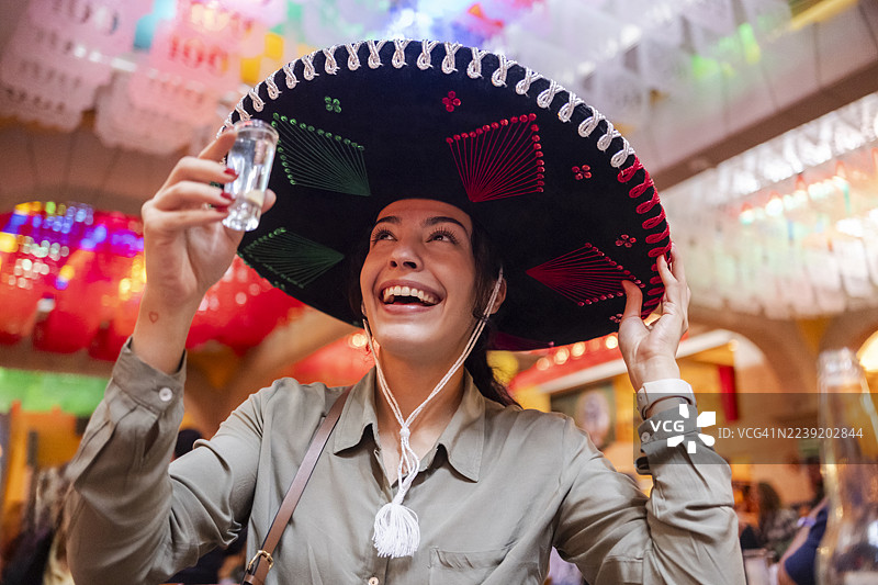 年轻游客在墨西哥国家假日期间品尝各种龙舌兰酒，头戴传统的萨罗帽。图片素材