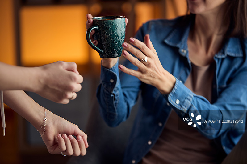 朋友们在温馨的聚会中分享咖啡杯，共享温暖时刻图片素材