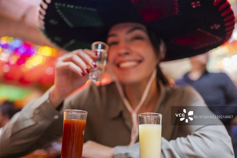 年轻游客在墨西哥国庆期间品尝各种龙舌兰酒，头戴传统的查罗帽。图片素材