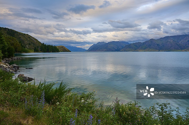 新西兰南岛奥塔哥哈威亚湖哈威亚，湖面辽阔，远眺云雾缭绕的山脉图片素材