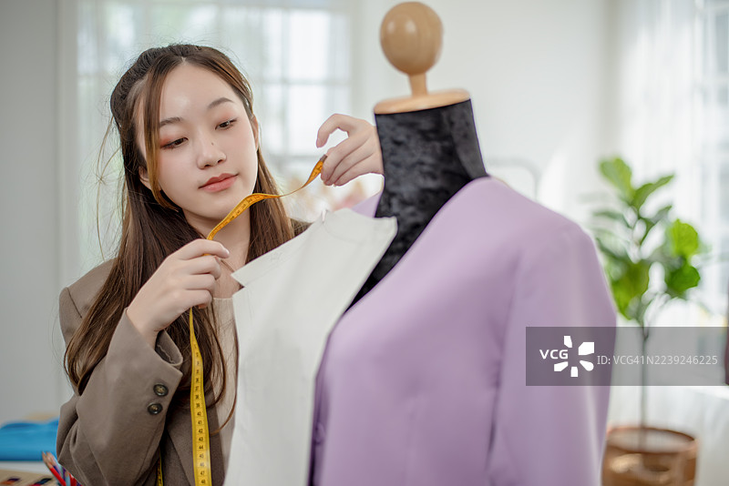 这位年轻的亚洲时尚设计师正运用她的创意和想法，打造出美丽且实穿的服装。图片素材