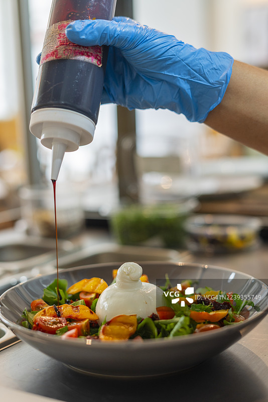 厨师在餐厅厨房准备美味的意大利布拉塔奶酪图片素材