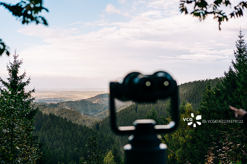 从观景台望去，前景中的望远镜聚焦着风景优美的山林景色。图片素材