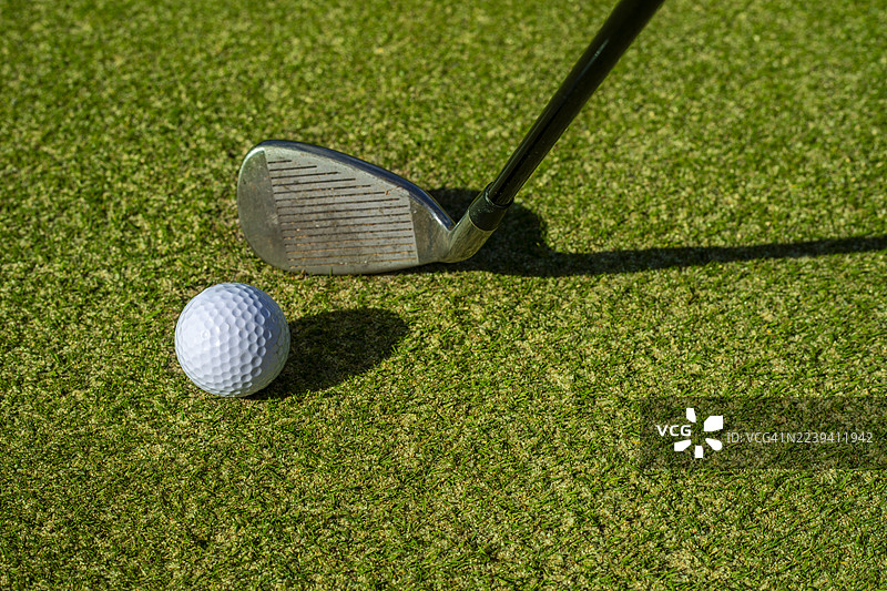 阳光下高尔夫球场上高尔夫球杆的特写图片素材