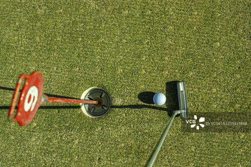 阳光明媚的球场上的高尔夫球杆特写图片素材