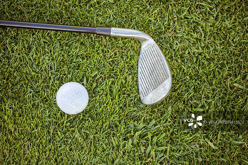 阳光明媚的球场上的高尔夫球杆特写图片素材