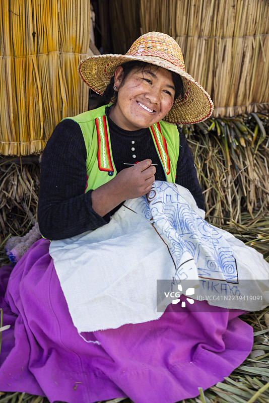 秘鲁乌鲁斯浮岛上的秘鲁年轻女子售卖纪念品，的的喀喀湖，秘鲁图片素材