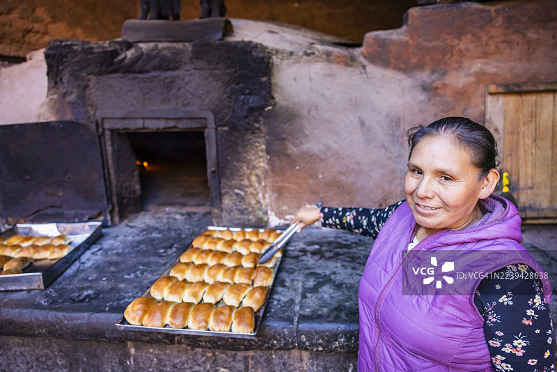 秘鲁妇女在皮萨克殖民时期古老陶炉中烘烤恩帕纳达斯，乌鲁班巴河谷图片素材