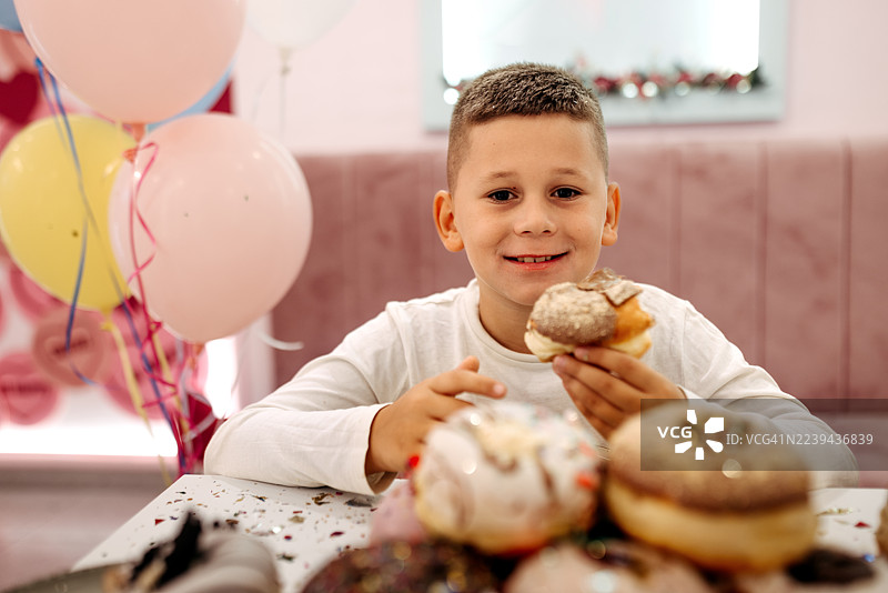 男孩在生日派对上吃甜甜圈图片素材