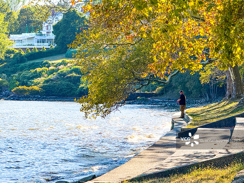 曼哈顿哈德逊河畔的尼亚克海滩州立公园，洛克兰县的男子在钓鱼图片素材