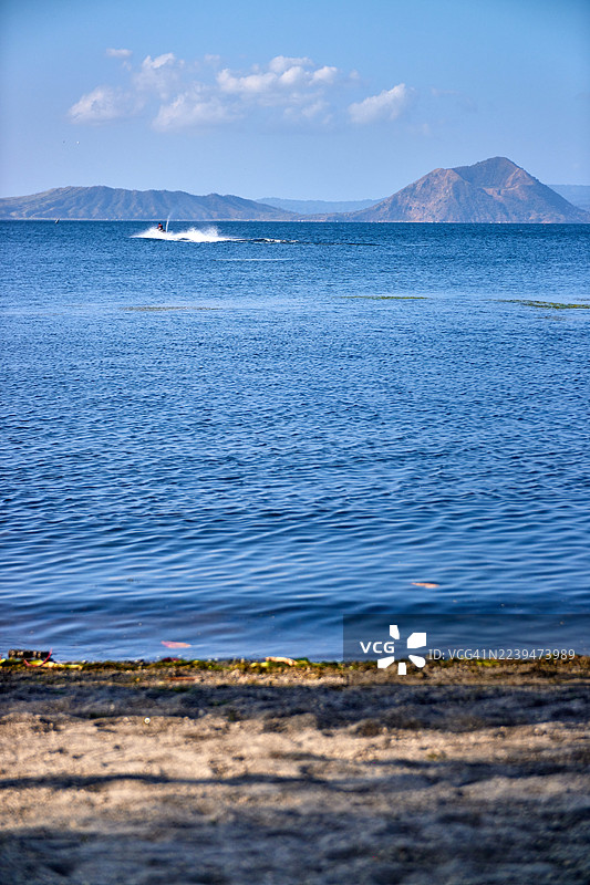 前景处，大大片塔阿尔湖从岸边延伸开去。图片素材