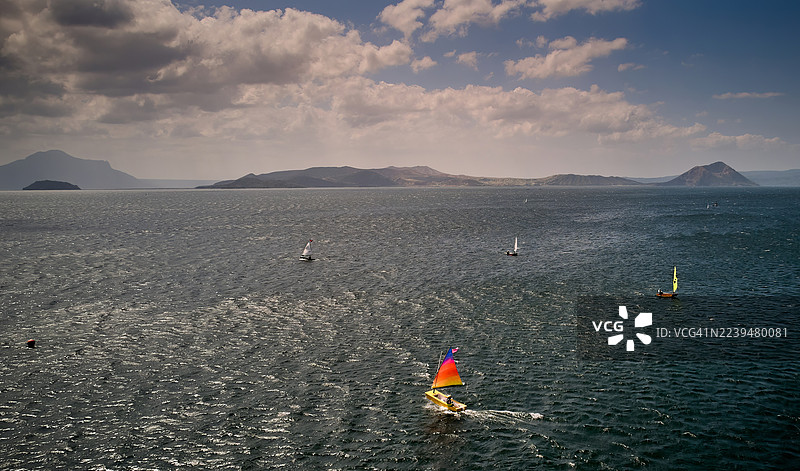 塔阿尔湖上的小型帆船赛，背景是塔阿尔火山。图片素材