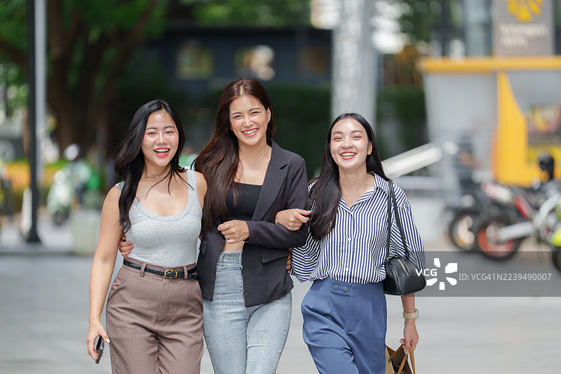 快乐的年轻亚洲女性朋友们在户外一起散步图片素材