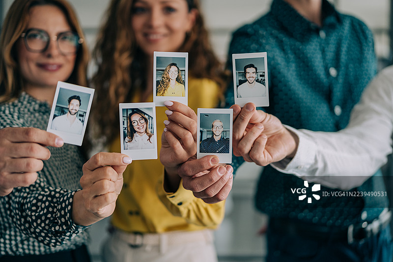快乐的同事们用拍立得相机拍照。图片素材