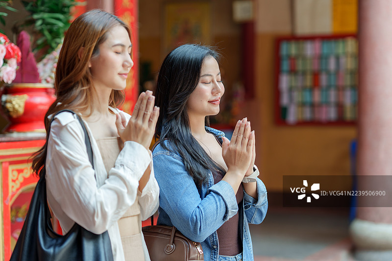 亚洲女性在寺庙中双手合十祈祷图片素材