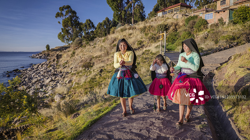 秘鲁的的喀喀湖塔基拉岛上，年轻女孩们正在用手纺羊毛。图片素材