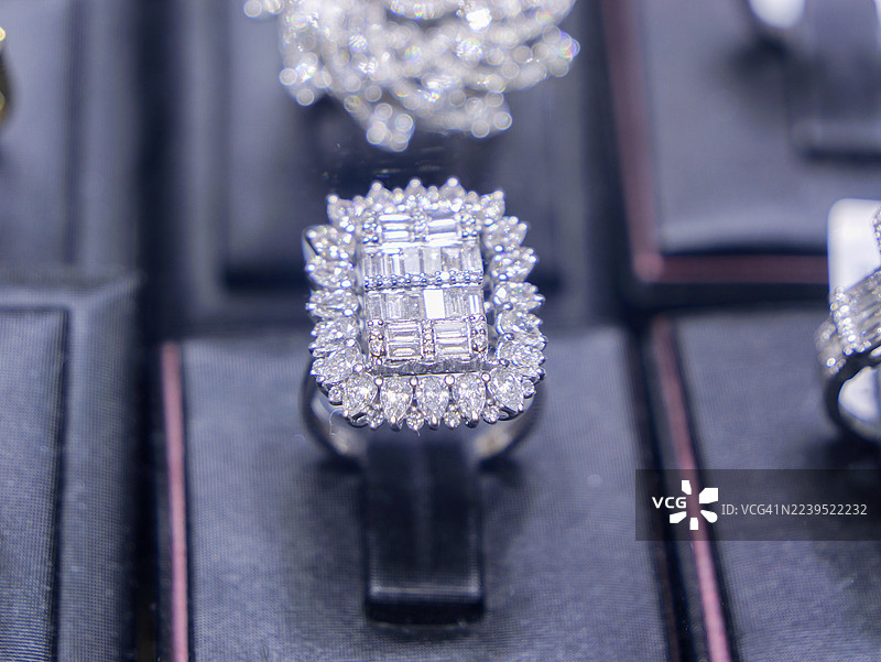 高端珠宝精品店黑色展示台上的法式镶嵌钻石戒指。图片素材