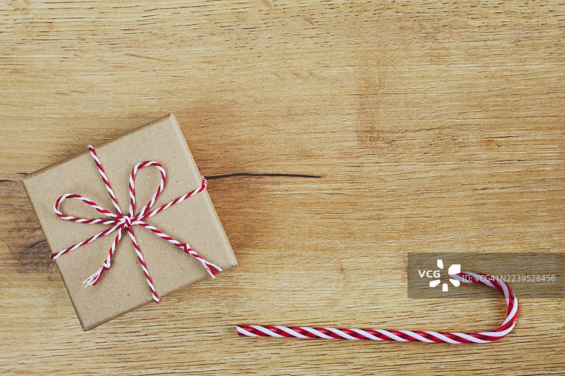 木桌上带有红白麻绳和糖果拐杖的乡村风礼品盒图片素材