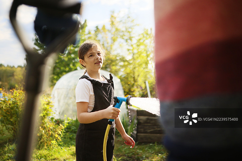 父亲和女儿在阳光明媚的日子里打理花园图片素材