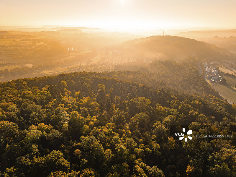 秋日森林景观，在初升太阳的朦胧光线下，赫尔曼·黑塞铁路，奥斯特尔斯海姆，黑森林，德国图片素材