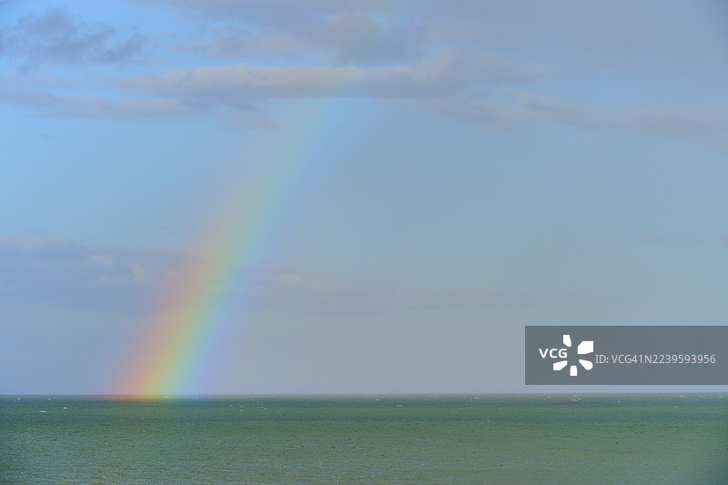 多云天空下的蓝色大海上的彩虹，莫拉基，汉普登，北奥塔哥，南岛，新西兰图片素材
