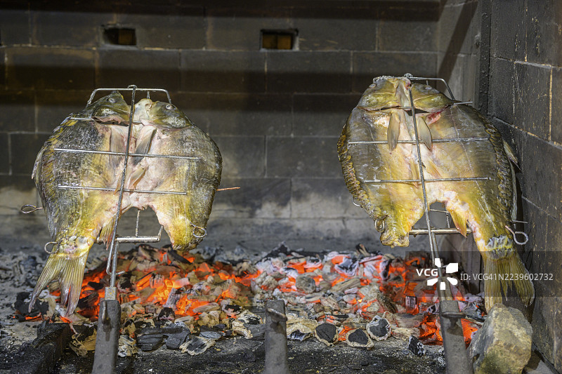 克罗地亚奥西耶克-巴兰亚县兹马耶瓦茨Josic餐厅地窖巷中，一条鲤鱼在炭火上烘烤图片素材