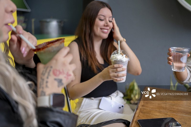 女孩们在咖啡店享用她们制作的饮品图片素材