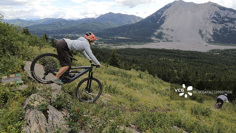 山地车手从山顶沿着陡峭的山路俯冲而下图片素材