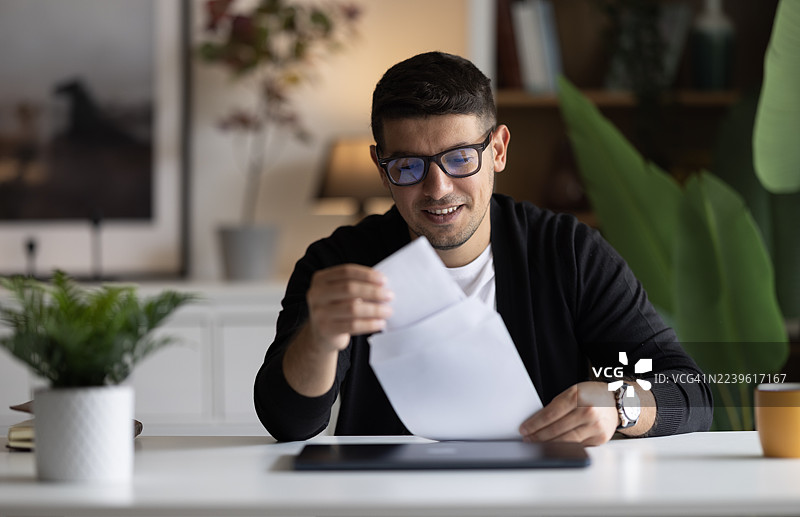 兴奋的高加索男人收到信件新闻，感到欣喜若狂图片素材