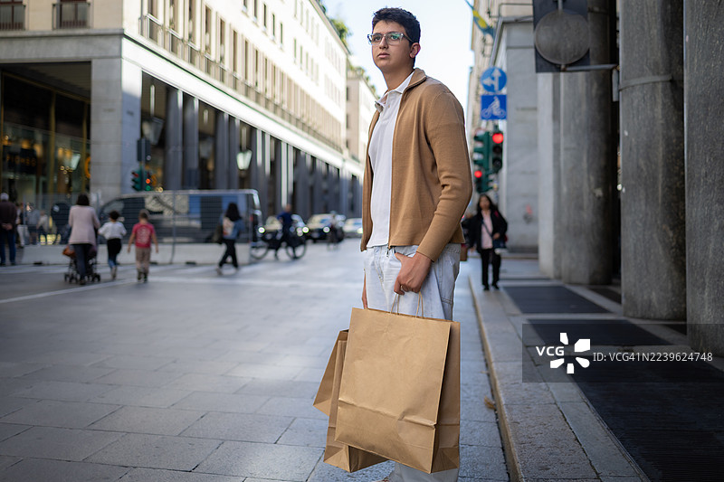一个少年在城市里逛街购物。图片素材