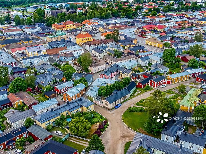 高角度拍摄的风景如画的欧洲小镇，拥有色彩缤纷的建筑和蜿蜒的街道，周围环绕着郁郁葱葱的绿树。图片素材