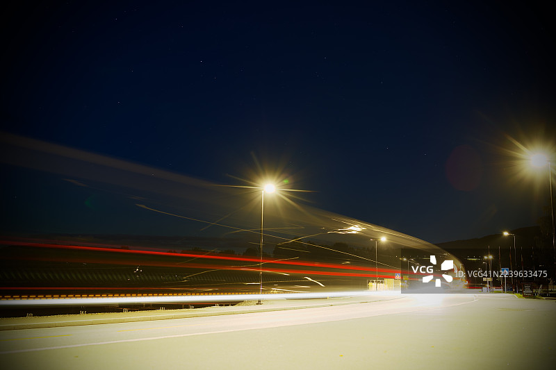 夜间道路上的车辆光轨长曝光镜头，街道灯光照亮现场，挪威，耶夫纳克图片素材