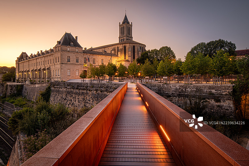 落日时分，灯火通明的现代桥梁通往历史建筑，融合了新旧建筑风格，法国图片素材