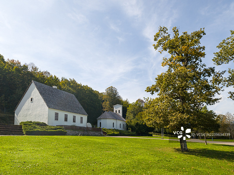 通往历史建筑的步行道，周围环绕着茂密的绿草和树木，天空晴朗，位于克罗地亚的斯米尔扬图片素材